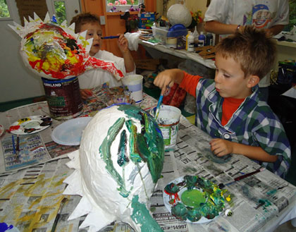 The twins applied their considerable energy and talents to painting colorful dragon pi�atas.